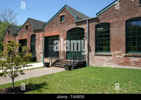 Fassade eines alten Seide Mühle. Die Fassade aus rotem Backstein, industrielle Türen und alten grünen Türen. Stockfoto