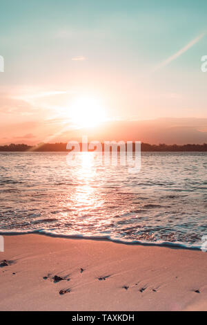 Orange Teal Sonnenaufgang am Strand von Gili Trawangan, Lombok. Lebendige Sonnenuntergang über Strand und Meer Wasser. Eine Strandszene mit Sunrise im Hintergrund. Stockfoto