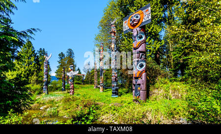 Bunte indigene Totempfähle, die Kunst und religiöse Symbole der Westküste der indigenen Völker im Stanley Park in Vancouver, Kanada platziert Stockfoto