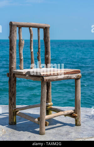 Holzstuhl in leeren Cafe neben Meer Wasser in tropischen Strand. Close Up. Insel Koh Phangan, Thailand Stockfoto