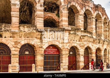 VERONA (VR), Italien - 10. MAI 2019: Touristen, die in der Arena von Verona, während Akteure in römischen Kostüme chatten Stockfoto