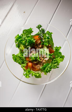 Salat mit Fleisch, Huhn, Salat, Dill, Tomaten auf weißem Holz Hintergrund. Für das Menü Restaurant Bar Cafe Stockfoto
