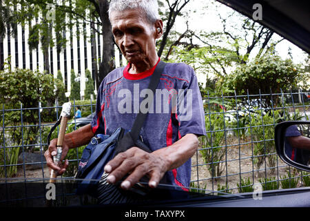 PASIG CITY, Philippinen - 19. MAI 2019: einem blinden Bettler bittet um Almosen oder lose änderung von vorbeifahrenden Autos und Fahrzeuge. Stockfoto