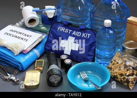 Im Voraus für eine Naturkatastrophe vorzubereiten durch die Zusammenstellung wichtiger Elemente, die Ihnen helfen, zu überleben. Wasser, Nahrung, Obdach, Lichtquelle, Erste Hilfe Kit. Stockfoto