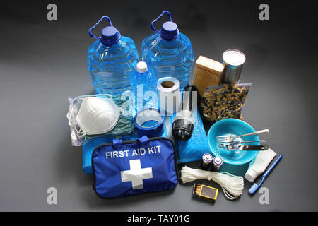 Im Voraus für eine Naturkatastrophe vorzubereiten durch die Zusammenstellung wichtiger Elemente, die Ihnen helfen, zu überleben. Wasser, Nahrung, Obdach, Lichtquelle, Erste Hilfe Kit. Stockfoto