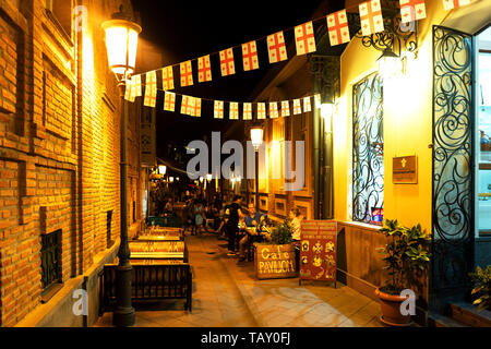 Georgien, Tiflis - September 24, 2018: Gemütliche Straße in Tbilisi mit Street Cafe und Touristen mit Girlande der nationalen Flaggen dekoriert Stockfoto