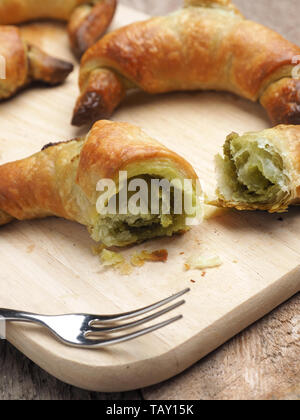 Leckere Croissants mit Matcha auf einem Schneidebrett, gesundes Frühstück Konzept Stockfoto