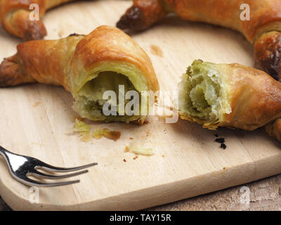 Leckere Croissants mit Matcha auf einem Schneidebrett, gesundes Frühstück Konzept Stockfoto