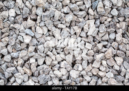 Nahaufnahme des Kleinen grau beige blau gebrochen Schotter Felsen liegen auf dem Boden. Natürliche Umwelt Hintergrund Textur. Garten Schutt macadam t Stockfoto