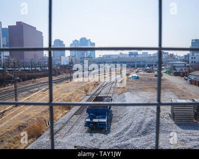 Seoul, Südkorea - März 2018: Foto von hinter einem Gitter, Blick auf den Bahnhof mit Schienen und Schotter genommen. Stadt ​​Background. Stockfoto