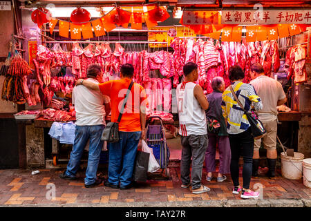 Die Menschen vor Ort kaufen Fleisch bei einem Metzger Shop im Bowrington Straße Food Market, Hongkong, China Stockfoto