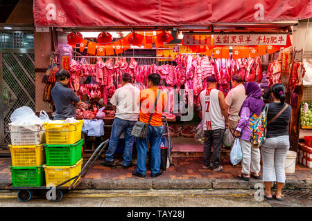 Die Menschen vor Ort kaufen Fleisch bei einem Metzger Shop im Bowrington Straße Food Market, Hongkong, China Stockfoto