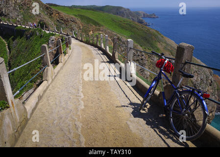 Fahrrad lehnte sich gegen das Geländer auf der malerischen La Coupee Causeway auf Sark Insel, wo keine Autos erlaubt sind - Guernsey, Channel Islands, Großbritannien Stockfoto