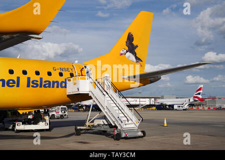 Aurigny airlines Embraer 195 mit einem fliegenden Papageitaucher auf seinem Schwanz am Flughafen London Gatwick geparkt lackiert Stockfoto