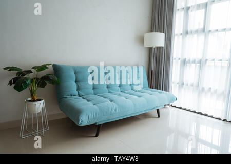 Bequemes Sofa im Wohnzimmer neben dem Fenster Stockfoto