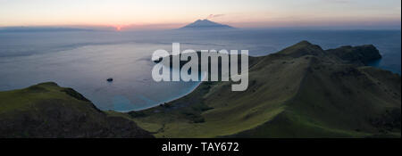 Die untergehende Sonne Silhouetten Sangeang Api, ein aktiver Vulkan liegt etwas außerhalb von Komodo National Park, Indonesia. Dies ist Teil der Ring des Feuers. Stockfoto