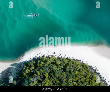 Strand Antenne Sommer mit Boot und blauen tropischen Wasser. Schönen Gold Küste heiß drone Shot mit Boot und sand Drift. Stockfoto