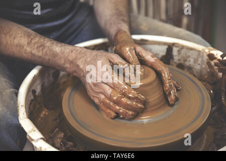 Töpferei. Der Meister am Rad des Töpfers, produziert ein Gefäß aus Ton. Stockfoto