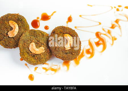 Hohen winkel Nahaufnahme eines grünes Gemüse Schnitzel mit unordentlichen Tomatensauce auf weiße Platte. Stockfoto