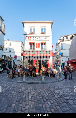 Paris, Frankreich, 12. April 2019: Leute auf der Terrasse des Restaurant Le Consulat in Montmartre am Abend sitzen an einem sonnigen Tag Stockfoto