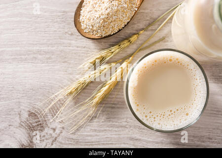 Hafer Milch in der Flasche und Glas auf hölzernen Tisch Stockfoto