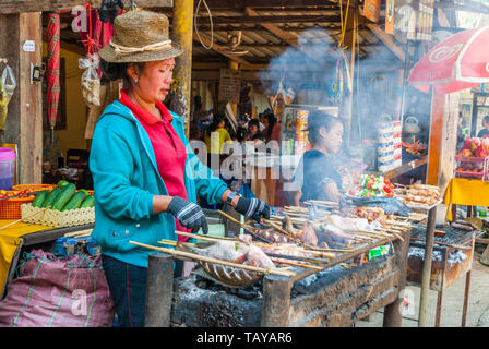 Luang Prabang, Laos - Feb 2016: Frauen grillen Fisch und im Restaurant treffen neben Kuang Si Wasserfall, Laos Stockfoto