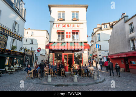 Paris, Frankreich, 12. April 2019: Leute auf der Terrasse des Restaurant Le Consulat in Montmartre am Abend sitzen an einem sonnigen Tag Stockfoto