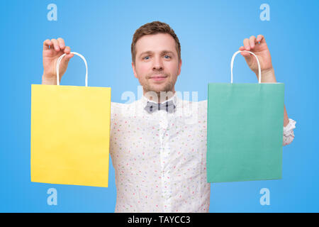Mann mit Haufen von Tüten mit Geschenken lächelnd Stockfoto