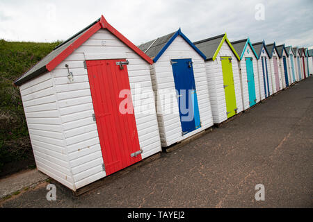 Bunten Badekabinen mit Moody himmel Goodrington Sands Beach, Devon, England Großbritannien Stockfoto