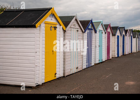 Bunten Badekabinen mit Moody himmel Goodrington Sands Beach, Devon, England Großbritannien Stockfoto