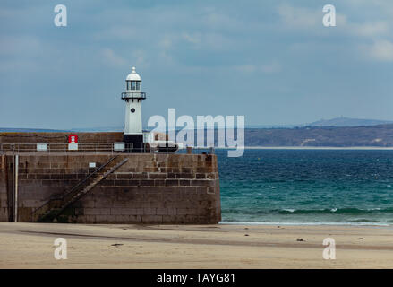 Smeatons Pier in St. Ives mit einem Weißen Leuchtturm am Hafen bei Ebbe. Stockfoto