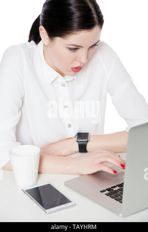 Ansicht von oben Portrait von aufmerksamen schwerwiegende attraktive Brünette Geschäftsfrau im Hemd sitzt mit Laptop und Suchen auf der Anzeige und etwas zu lesen. Stockfoto