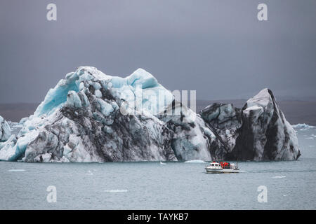 Riesiger Eisberg und resque Boot in Island Jokulsarlon Stockfoto