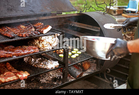 Man Köche verschiedene Arten von Fleisch und Gemüse auf dem Grill im Freien im Sommer Stockfoto