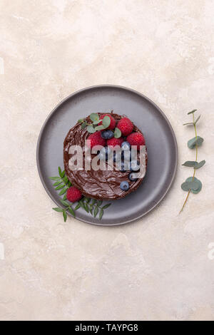 Geburtstag Kuchen mit Beeren auf hellen Hintergrund mit grünen Blättern. Flach, Ansicht von oben, Platz für Text Stockfoto