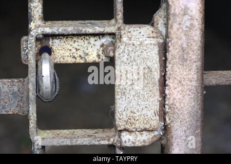 Detail einer Vorhängeschloss sichern ein altes rostiges Metall Tor oder Schranke Stockfoto