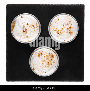 Honig cheesecake Dessert in einem Glas auf einen schwarzen Stein Platte auf weißem Hintergrund Stockfoto