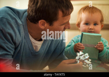 Gerne Vater Eröffnung präsentiert mit seiner kleinen Tochter. Stockfoto