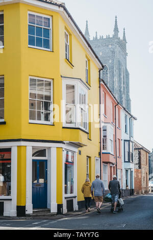 Cromer, Großbritannien - 20 April, 2019: Menschen zu Fuß vorbei an bunten Häuser in Cromer, einer Stadt am Meer in Norfolk und ein beliebter Ort für Familien, in Großbritannien. Stockfoto