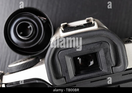 Von alten analogen Kamera und Schwarzen und Weißen neuen Film. Zubehör für die analoge Fotografie auf einen dunklen Tisch. Schwarzen Hintergrund. Stockfoto