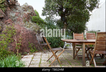 Hölzerne Stühle und Tisch in französischen Garten im April. Französische Riviera, Frankreich Stockfoto