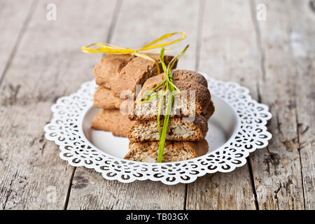 Frische italienische Kekse cantuccini auf weißem Schild auf ructic Holztisch Hintergrund gestapelt. Süße Speisen. Stockfoto