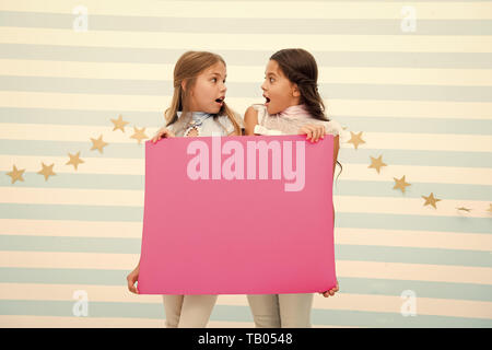 Schockierende Ankündigung Konzept. Unglaublich überraschende Nachrichten. Mädchen Halten Sie Werbebanner. Girls Kids holding Papier Banner für die Ansage. Überrascht Kinder mit leeren Papier kopieren Raum schockiert. Stockfoto