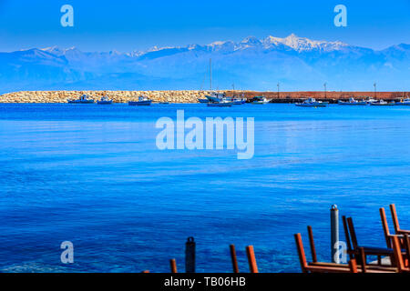 Cafe Taverne Tabellen und defocued Hintergrund der Berg Schnee Berge und Meer Panorama in Messenien, Peloponnes, Griechenland Stockfoto