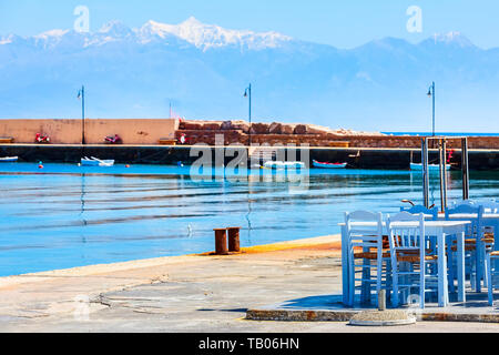 Cafe Taverne Tabellen und defocued Hintergrund der Berg Schnee Berge und Meer Panorama in Messenien, Peloponnes, Griechenland Stockfoto