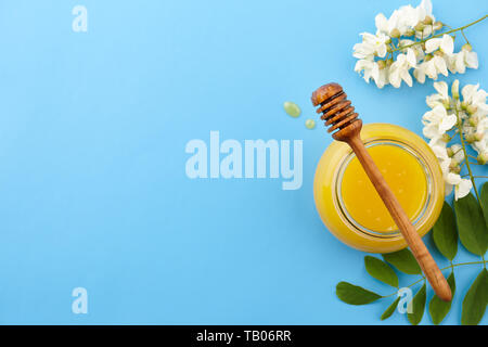 Honig mit acacia Blüten auf blauem Hintergrund Stockfoto