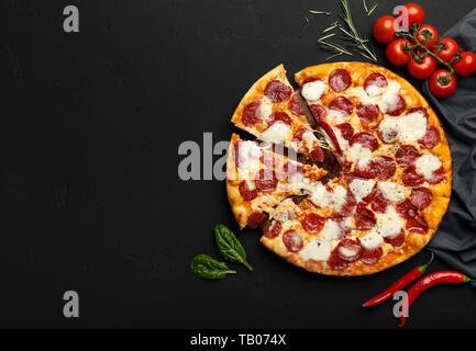 Frische Pepperoni Pizza auf schwarzen Hintergrund mit Freier Speicherplatz Stockfoto