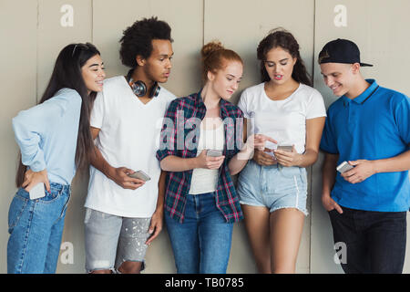 Gruppe von Jugendlichen Austausch von SMS auf dem Handy Stockfoto