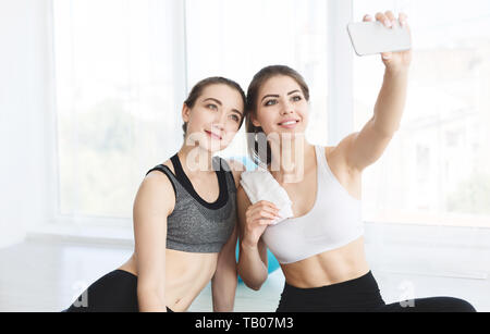 Charmante Freundinnen machen selfie nach Yoga Klasse Stockfoto