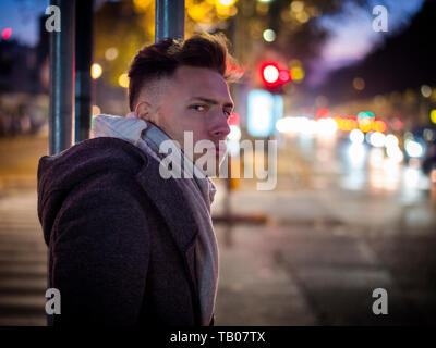 Schöne moderne, junge Mann, stehend auf einem Bürgersteig in der Nacht Stockfoto